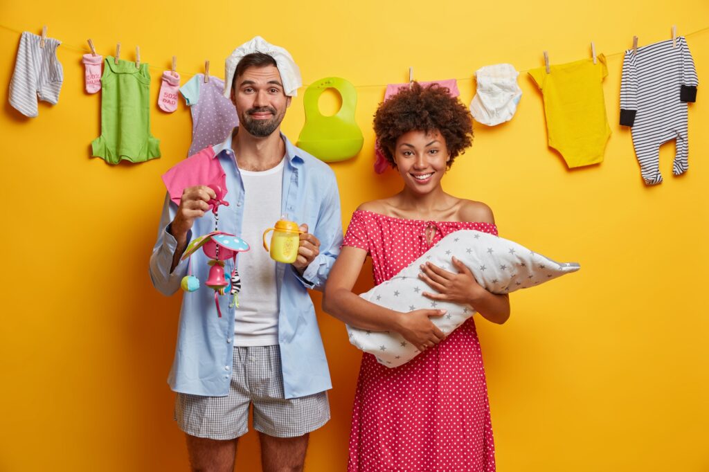 Happy family, child care concept. Father and mother pose with newborn child wrapped in blanket care